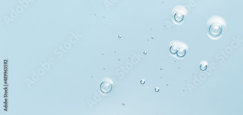 Water toner serum texture with bubbles. Blue skincare background. Cosmetic liquid product macro