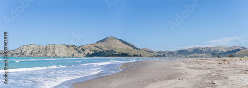 Panorama view of Tolaga Bay with surrounding hills under blue sky