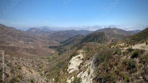 View across Santa Monica Mountains with low clouds covering peaks in the distance, seen from Backbone Trail in Southern California