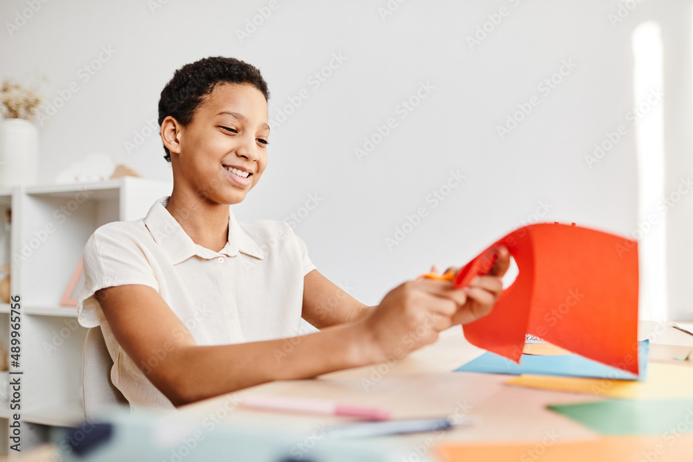 Portrait of smiling African American girl making DIY holiday card while enjoying arts and crafts at home, copy space Portrait of smiling African American girl making DIY holiday card while enjoying arts and crafts at home, copy space