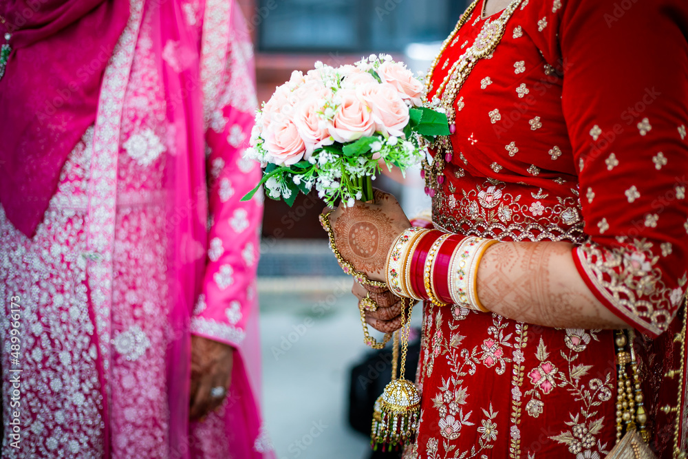 Indian bride's holding wedding flowers hands close up