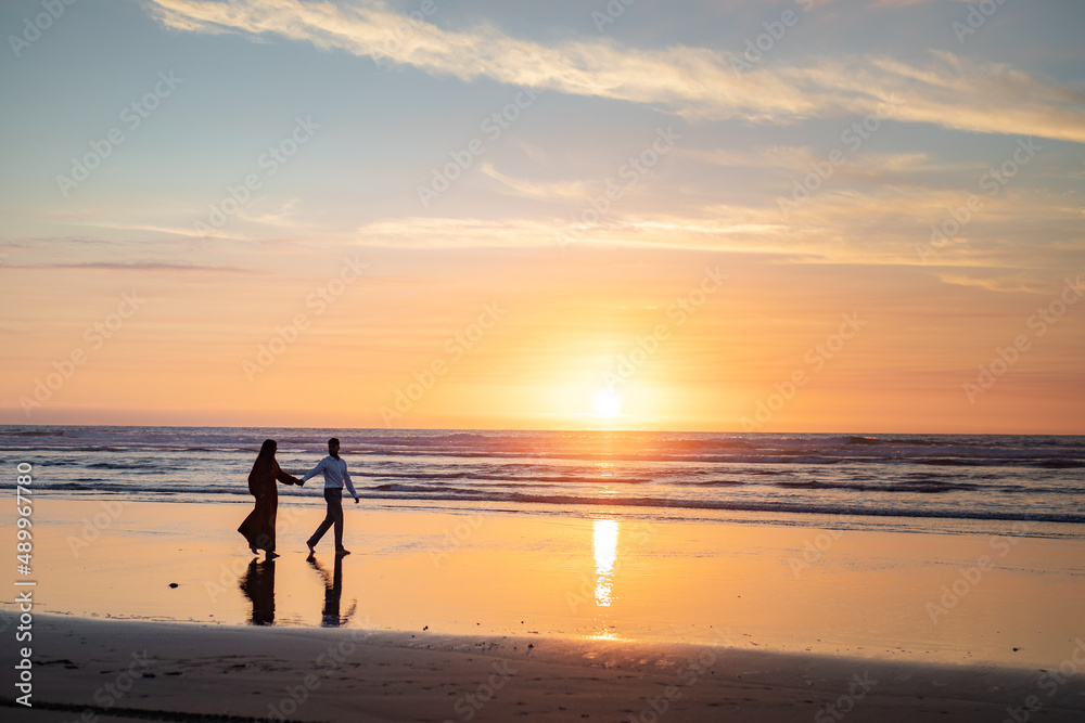 Married couple's silhouettes on the beach sunset