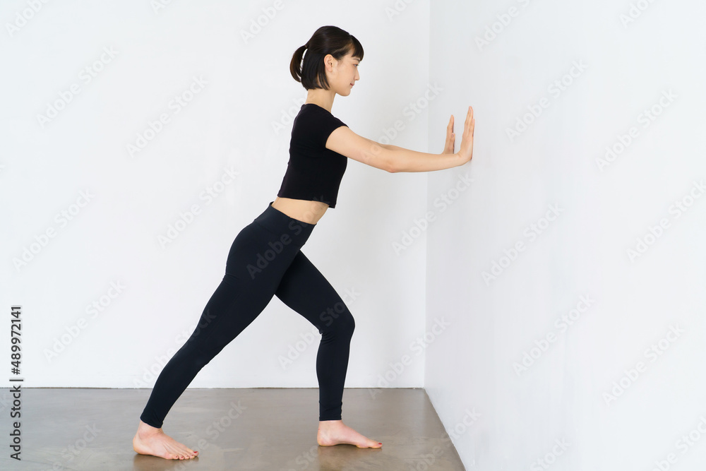 Fototapeta premium 壁を使って体操をする女性