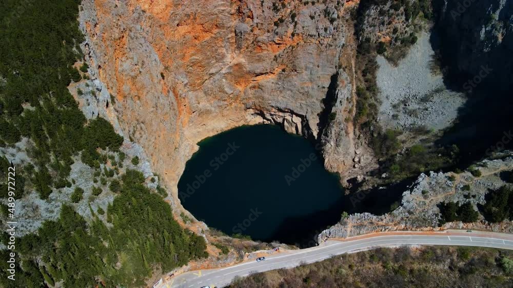 Top view of the Red Lake containing a karst lake close to Imotski, Croatia. The largest collapse doline in Europe with high cliffs and great depths. Beautiful scenic landscape view 4k UHD Top view of the Red Lake containing a karst lake close to Imotski, Croatia. The largest collapse doline in Europe with high cliffs and great depths. Beautiful scenic landscape view 4k UHD