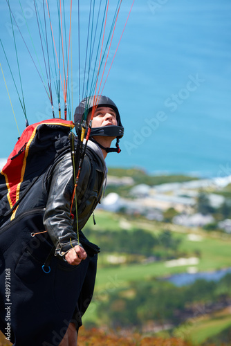 Soar into summer. Shot of a man paragliding on a sunny day.