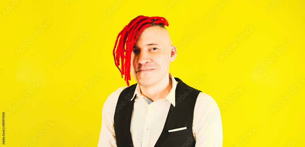 Close up of man hipster. Portrait businessman with red dreadlocks, isolated bright yellow color background