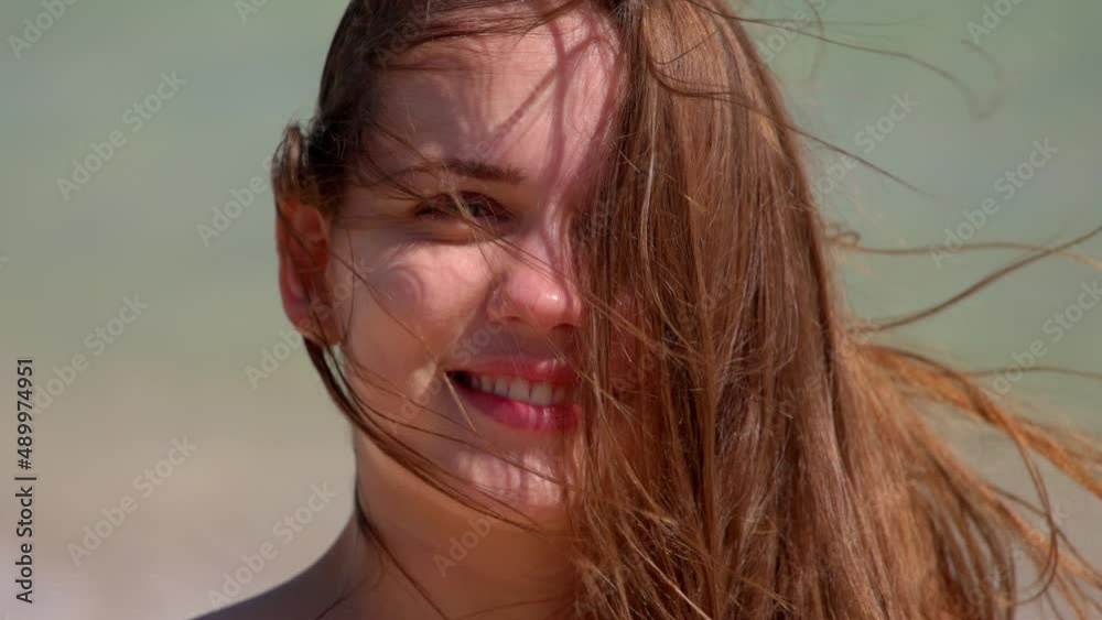 Close up shot of a young woman on a windy day at the beach Close up shot of a young woman on a windy day at the beach