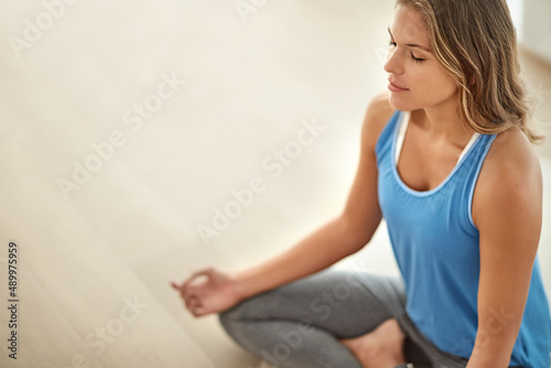 In a meditative mood.... Shot of a young woman meditating at home.