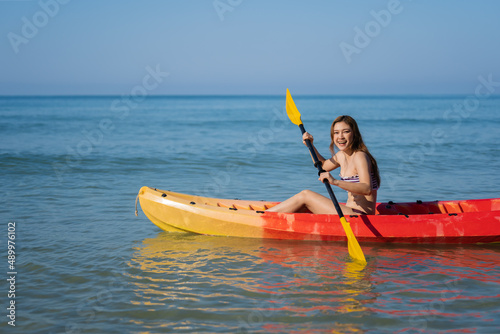 woman in swimsuit paddling a kayak boat in sea © geargodz