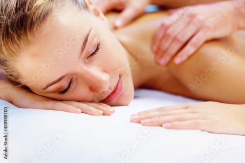 Young lady enjoying a body massage at a spa. Pretty young girl enjoying a body massage at a spa.
