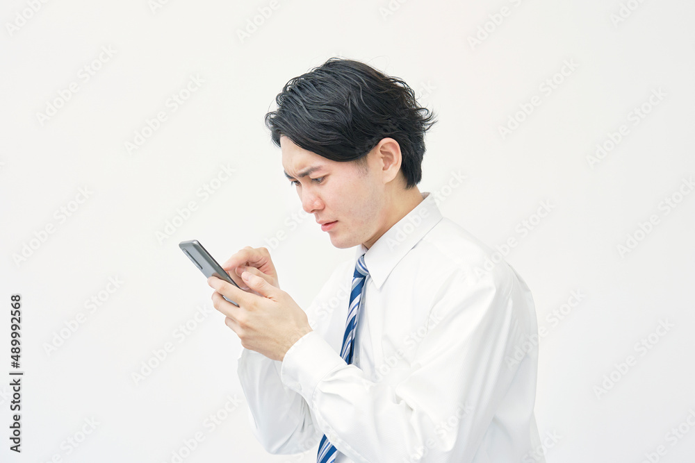 ビジネスマン　スマートフォン　不安　白背景