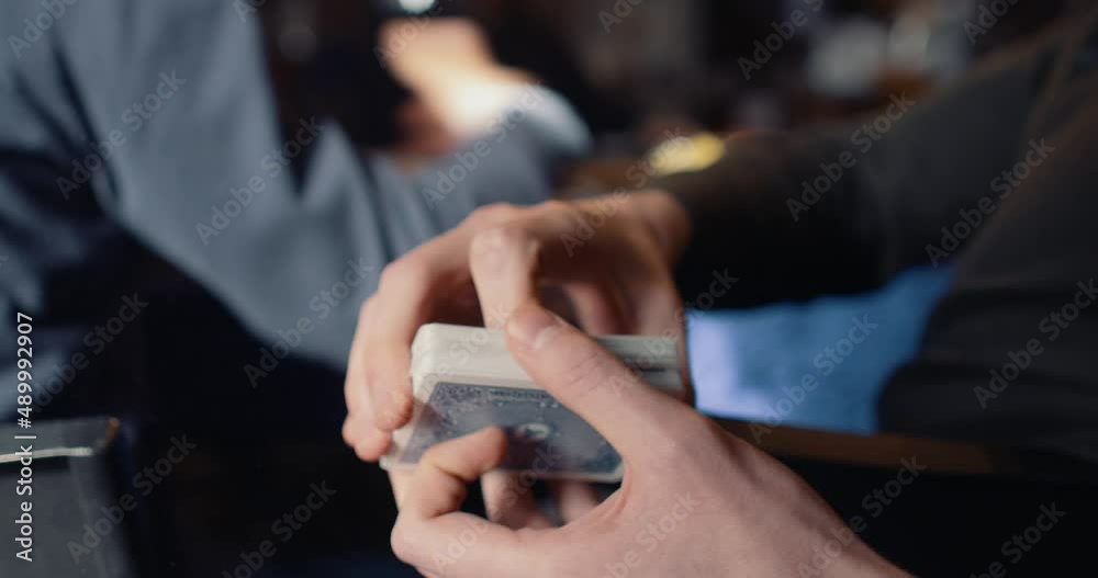 Close up of a pair of hands doing a cardistry trick called 