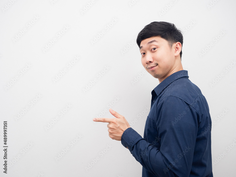 Man smile turn back and point finger at copy space Man smile turn back and point finger at copy space