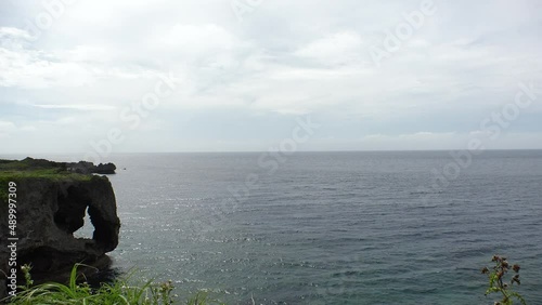 OKINAWA, JAPAN - AUG 2021 : View of sea and Cape Manzamo located near Onna son village in the Kunigami District. Wide view, real time shot in daytime. Summer holiday, vacation and resort concept video photo