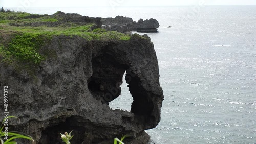 OKINAWA, JAPAN - AUG 2021 : View of sea and Cape Manzamo located near Onna son village in the Kunigami District. Wide view, real time shot in daytime. Summer holiday, vacation and resort concept video photo