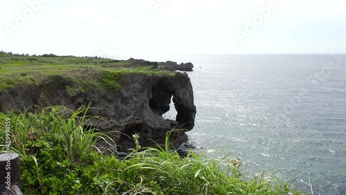 OKINAWA, JAPAN - AUG 2021 : View of sea and Cape Manzamo located near Onna son village in the Kunigami District. Wide view, real time shot in daytime. Summer holiday, vacation and resort concept video photo