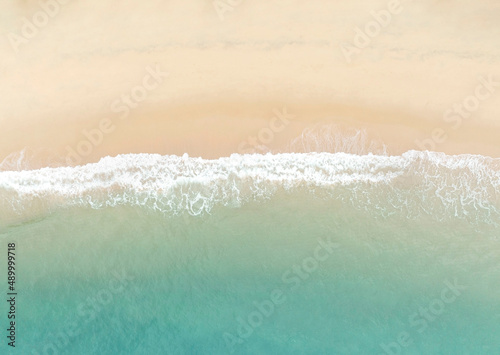 Aerial view of The background of turquoise color with wave water background on the summer beach at the seashore