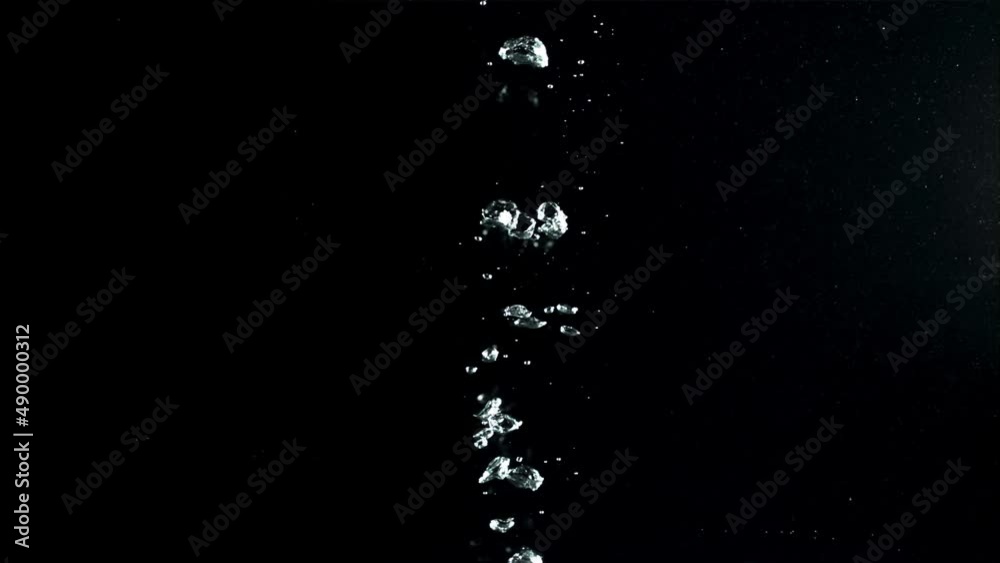 Air bubbles under water rise upwards. On a black background.Filmed on a high-speed camera at 1000 fps. High quality FullHD footage