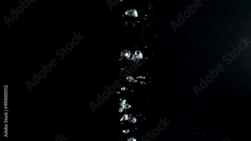 Air bubbles under water rise upwards. On a black background.Filmed on a high-speed camera at 1000 fps. High quality FullHD footage