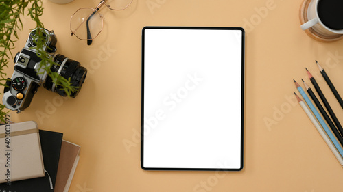 Workspace with tablet mockup on beige background.