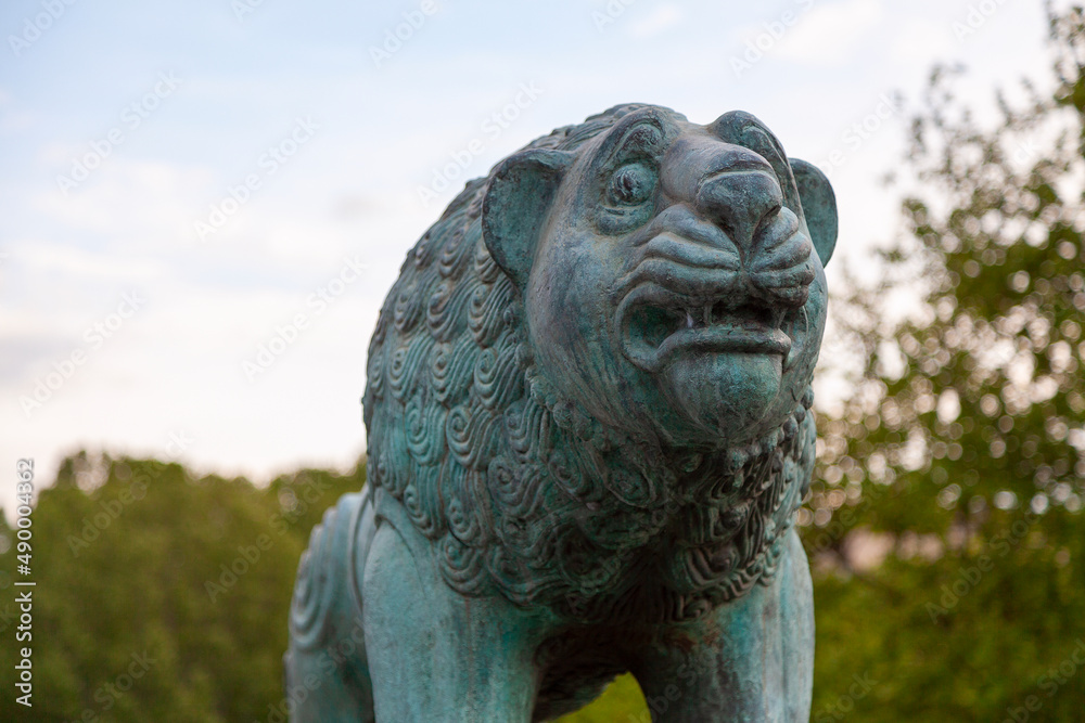 Bronze statue of a lion with traces of corrosion