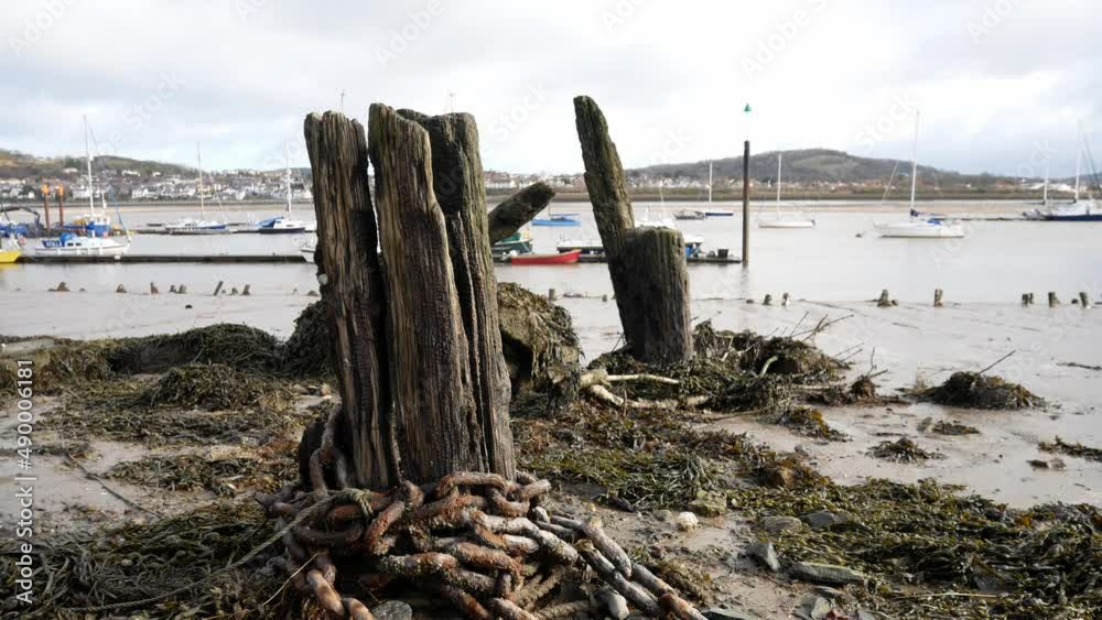 Rotten derelict old pier wood wreck on Conwy harbour shoreline Rotten derelict old pier wood wreck on Conwy harbour shoreline