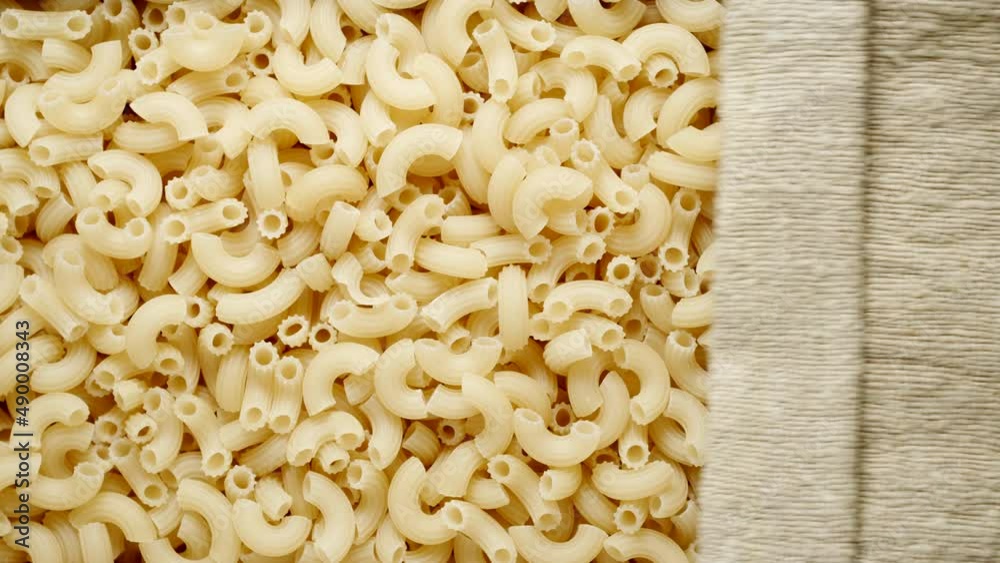 TOP VIEW: Macaroni pasta under opening sackcloth TOP VIEW: Macaroni pasta under opening sackcloth