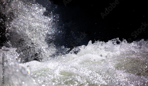 Drops of water, splashing and bubbling waterfall as a background. Foam party or laundry. The concept of freshness of soft drinks.