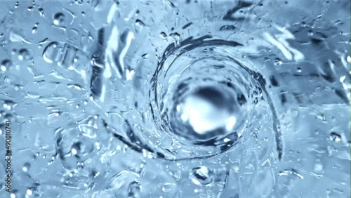 A whirlpool of water with air bubbles. Top view. Macro background.Filmed is slow motion 1000 fps. photo