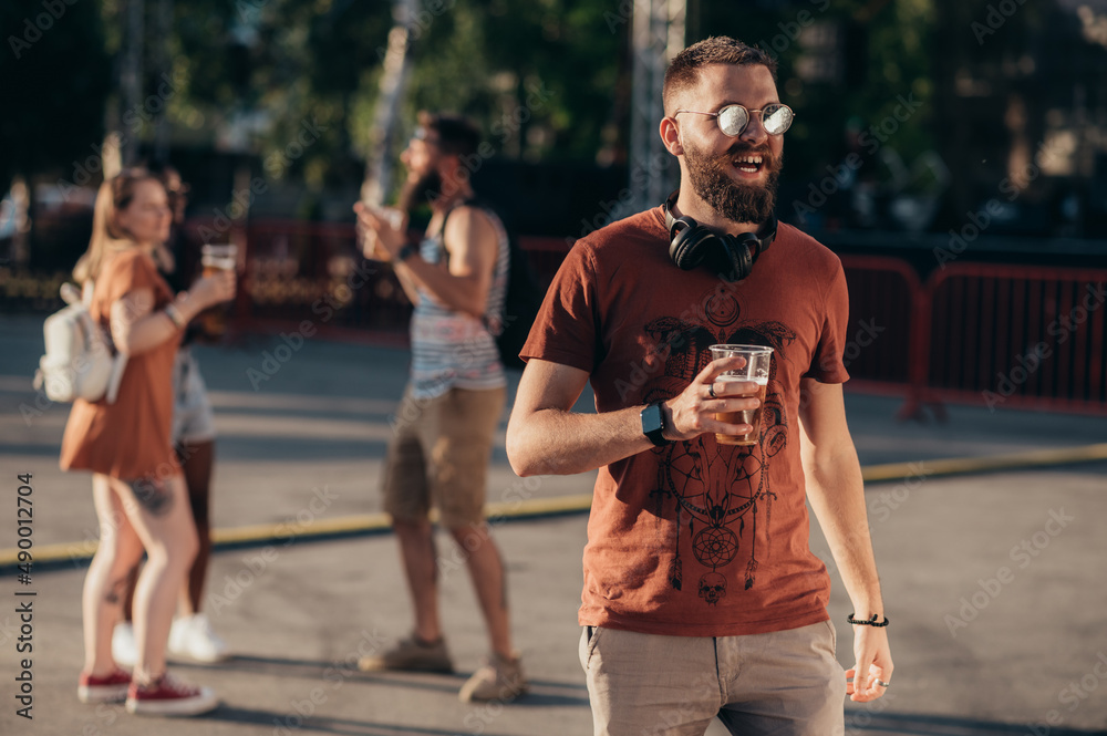 Obraz premium Group of friends drinking beer and having fun at music festival