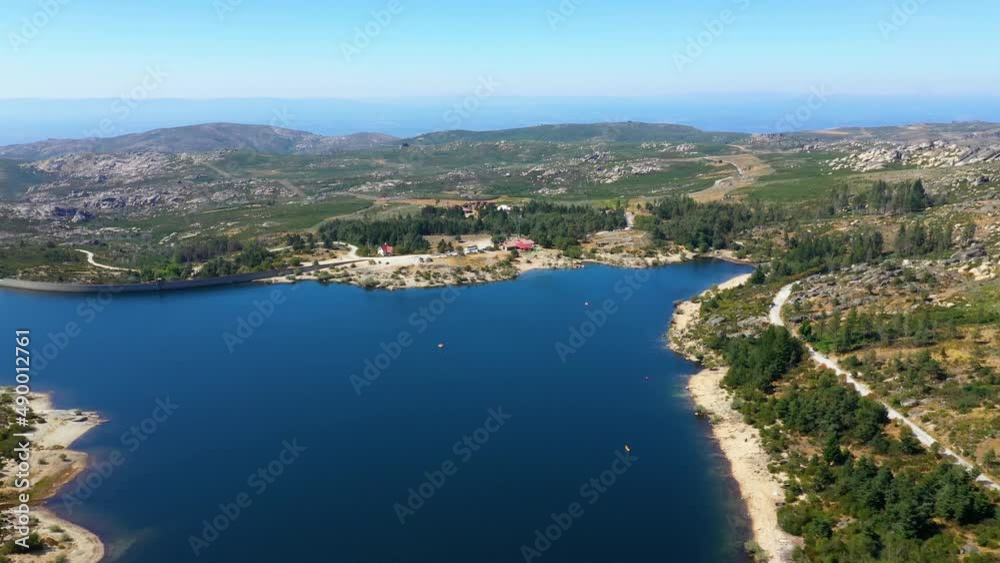 Aerial view overlooking lake Vale do Rossim, in sunny Serra da Estrela, Portugal - tracking, drone shot Aerial view overlooking lake Vale do Rossim, in sunny Serra da Estrela, Portugal - tracking, drone shot