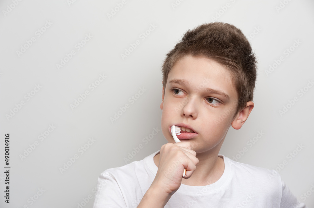 The boy cleaning his teeth using a toothbrush and toothpaste. Dental and oral care The boy cleaning his teeth using a toothbrush and toothpaste. Dental and oral care