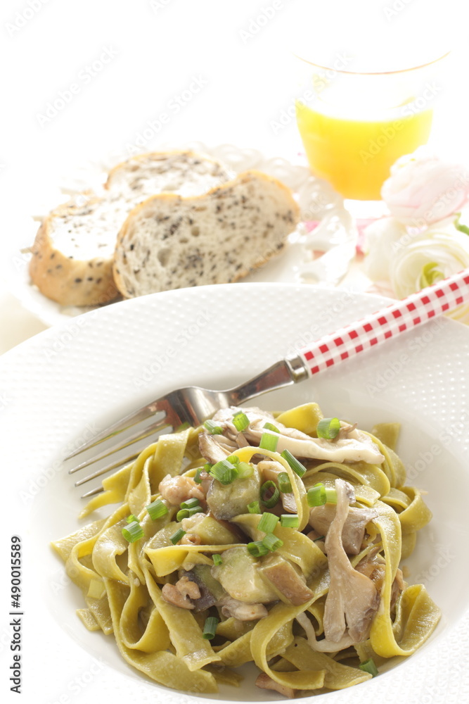 Homemade Italian food, eggplant and mushroom with spinach fettuccine serving with sesame bread