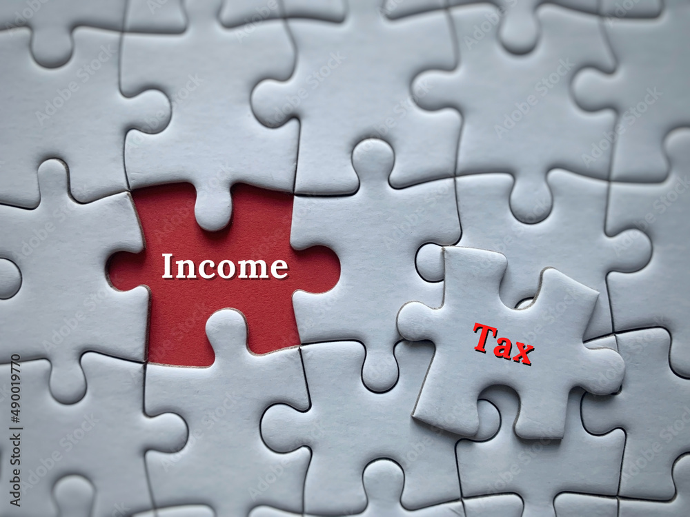 Top view of word surrounded by with jigsaw puzzle - Income tax. Business concept Top view of word surrounded by with jigsaw puzzle - Income tax. Business concept