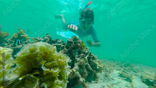 A boy in an underwater mask cleans the seabed from pollution. The concept of nature conservation.