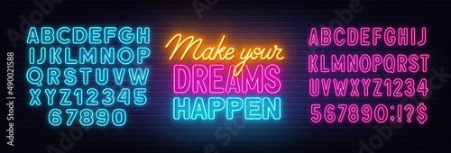 Make Your Dreams Happen neon lettering on brick wall background.