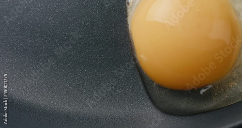 Egg pour frying pan sunny side up cooking top down in macro close up