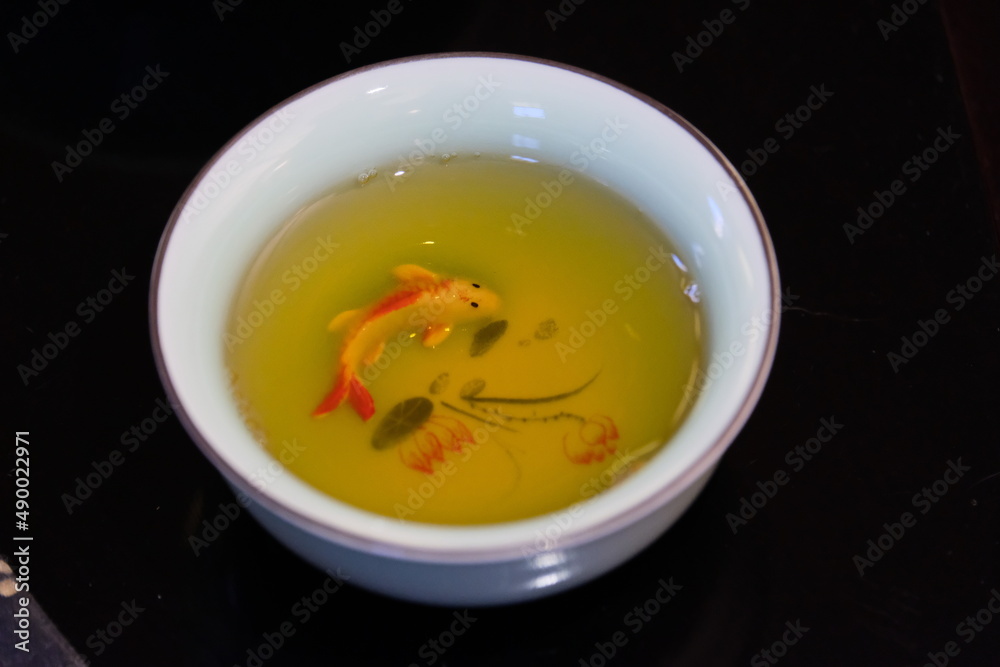 Fish in freshly brewed green tea in a white Cup Fish in freshly brewed green tea in a white Cup