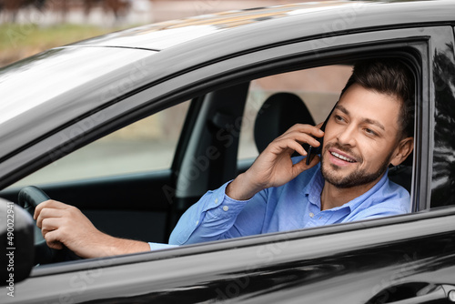 Handsome businessman talking by mobile phone in modern car © Pixel-Shot