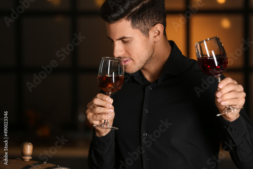 Young male sommelier tastin...