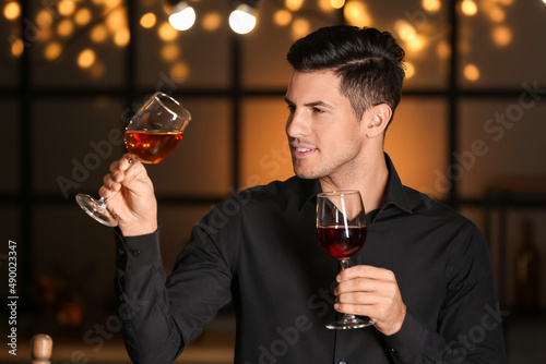 Young male sommelier tastin...