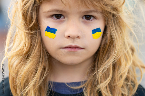 Fototapeta Sign of ukrainian flag on child cheek