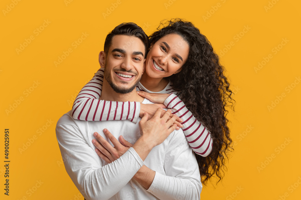 Fototapeta premium Happy Millennials. Beautiful Smiling Arab Couple Embracing And Looking At Camera