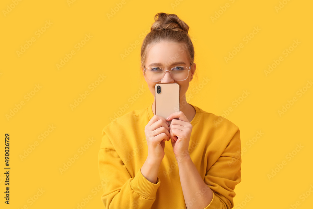 Pretty young woman with mobile phone on yellow background Pretty young woman with mobile phone on yellow background