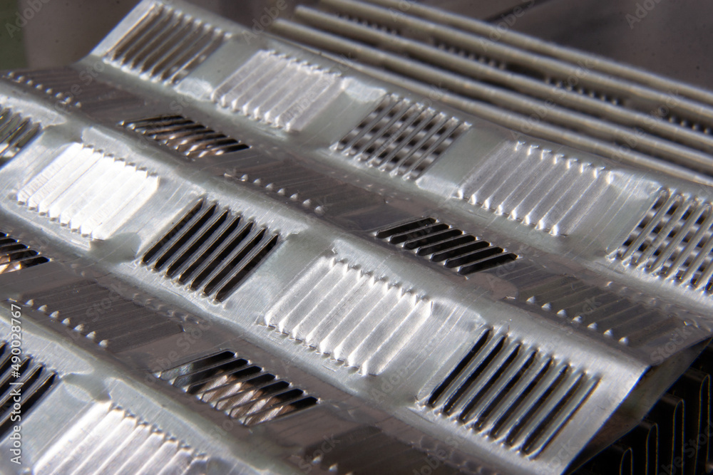 shiny metallic waves of bent metal. aluminum stamping in production shiny metallic waves of bent metal. aluminum stamping in production