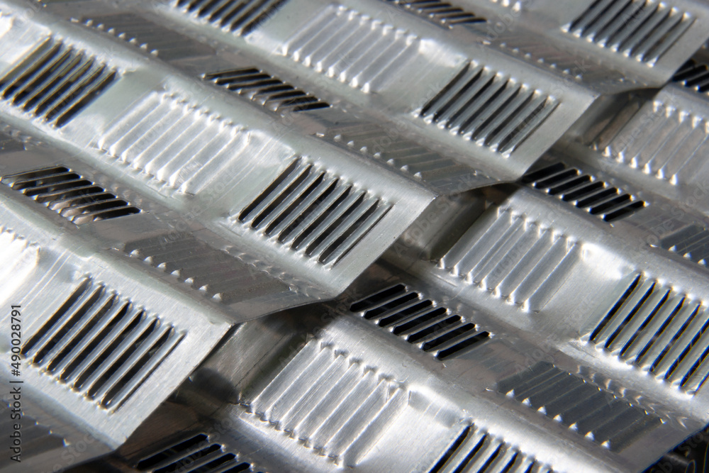 shiny metallic waves of bent metal. aluminum stamping in production shiny metallic waves of bent metal. aluminum stamping in production