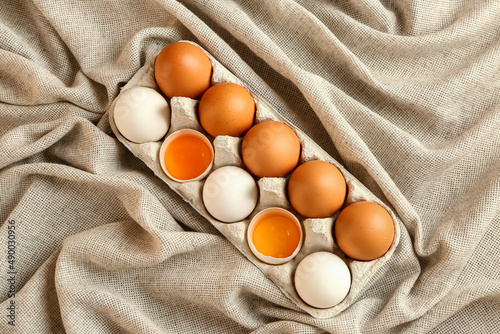 Holder with fresh chicken eggs on table