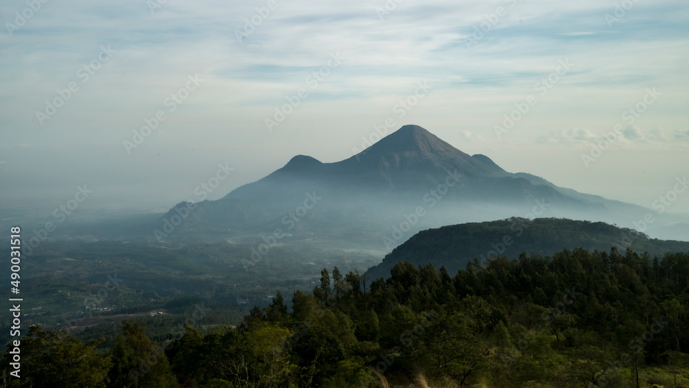 Landscape view of misty Mount Penanggungan at early morning, East java, Indonesia, landscape wallpaper, defocused background Landscape view of misty Mount Penanggungan at early morning, East java, Indonesia, landscape wallpaper, defocused background