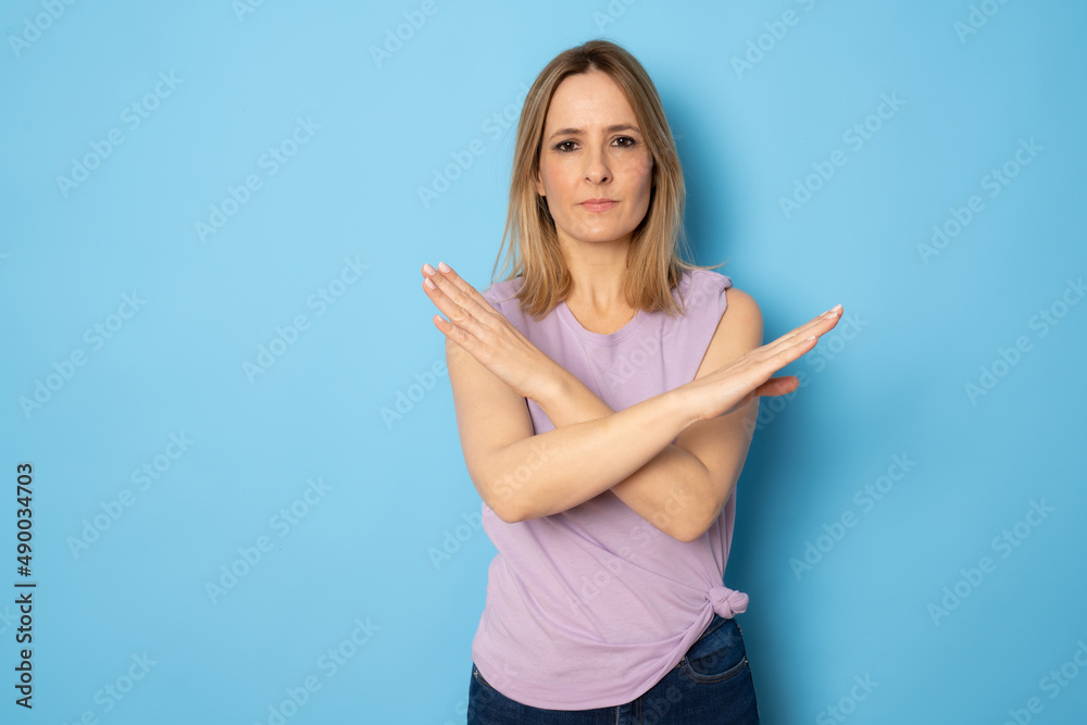 Angry and frustrated woman shows her crossed arms gesture. Stop sign concept. Angry and frustrated woman shows her crossed arms gesture. Stop sign concept.