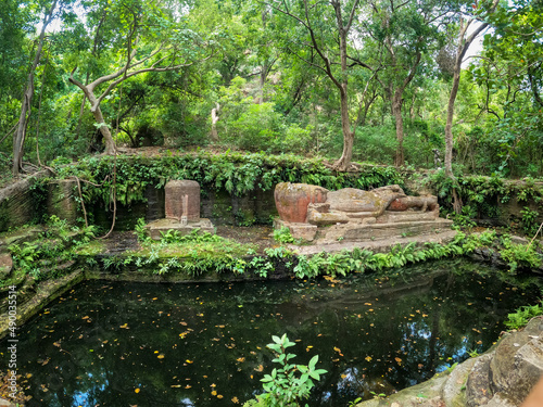 horizontally laid statue of lord vishnu Shesh Shaiya on the seven hooded serpent and shiva linga and brahma trinity of gods at Bandhavgarh national park, umaria madhya pradesh, India